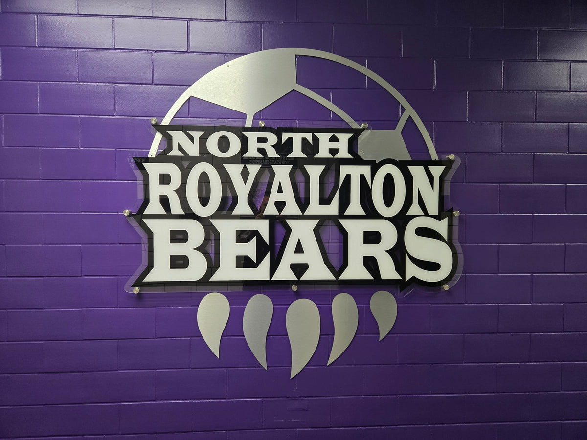 High-end architectural athletic branding using clear acrylic with opaque white ink backing and Brushed Aluminum contour cut 3mm DiBond. In North Royalton, OH